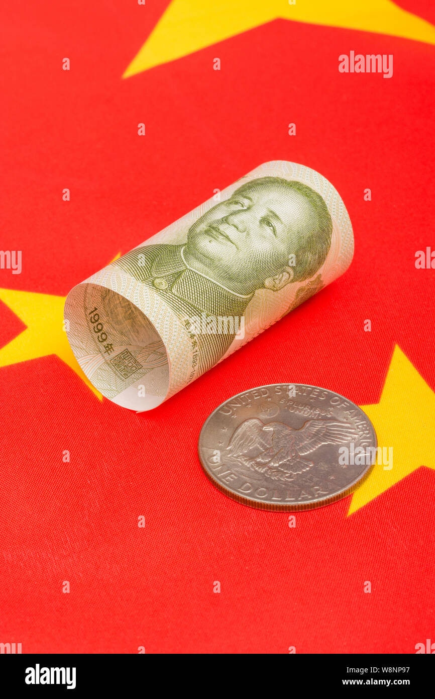 Close-up shot U.S. Silver Dollar with Chinese 1 Yuan Renminbi banknote and red Chinese flag. Metaphor US-China trade war, currency manipulation. Stock Photo