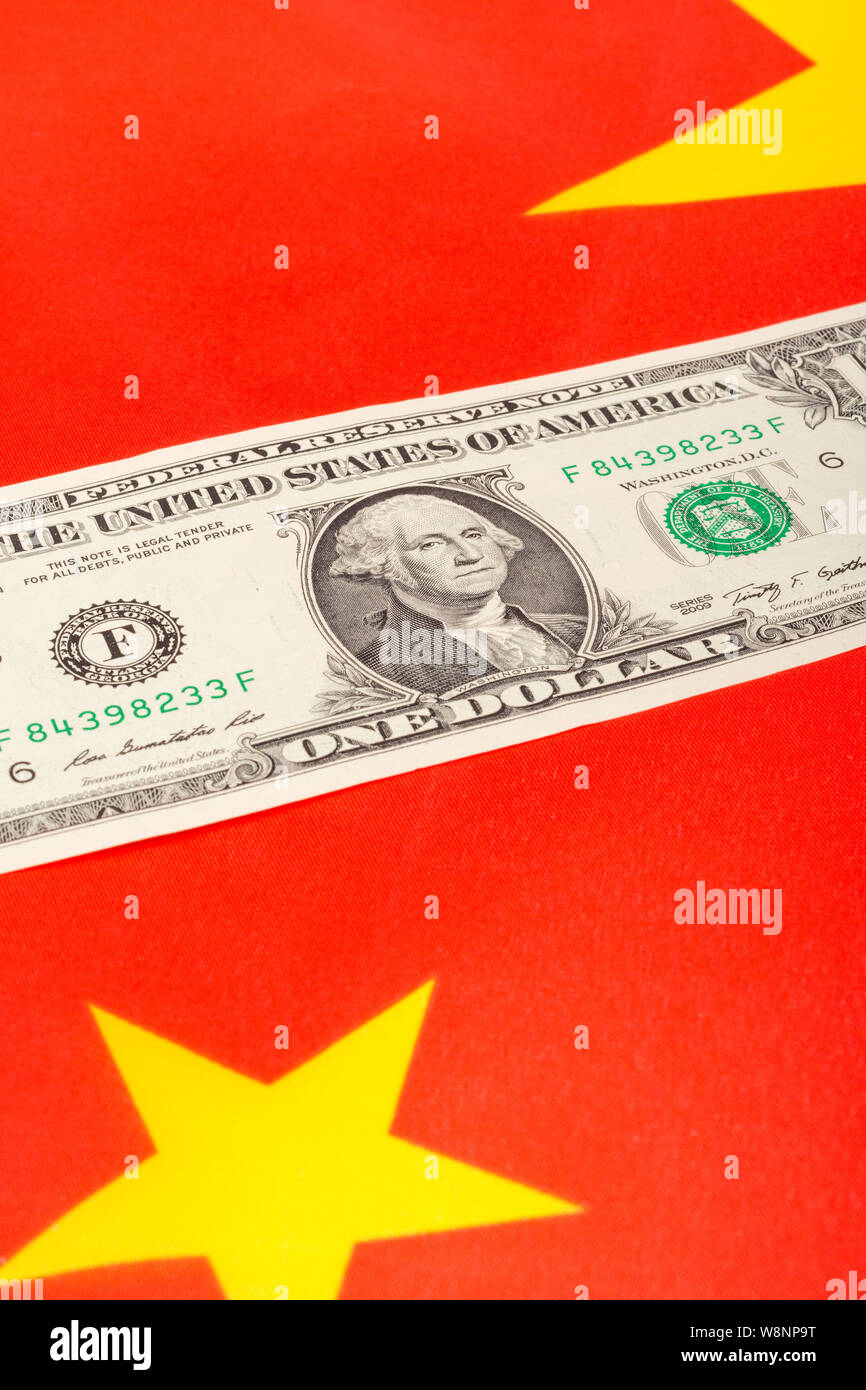 Close-up shot U.S. 1 Dollar bill banknote, and red Chinese flag. Metaphor US-China trade war, currency war, currency manipulation, trade war China. Stock Photo