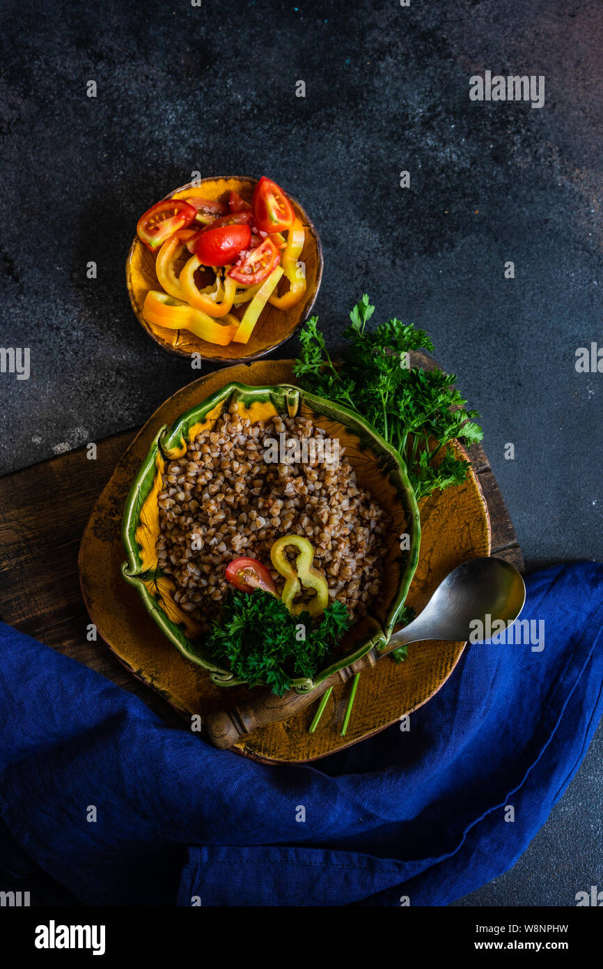 Keto diet concept with boiled buckwheat seeds and vegetables in a