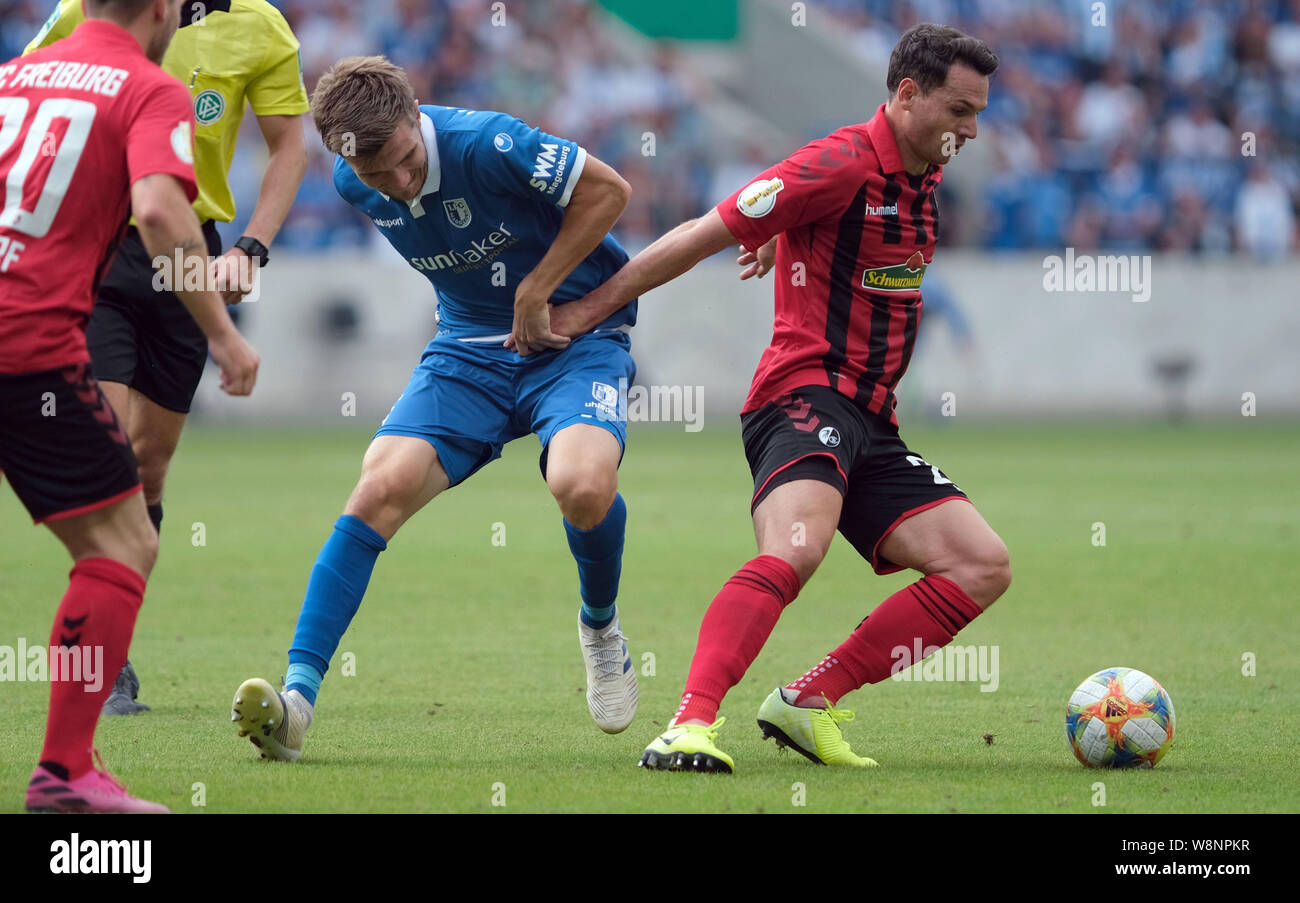 Magdeburg, Germany. 10th Aug, 2019. Soccer: DFB Cup, 1st FC Magdeburg - SC Freiburg, 1st round in the MDCC-Arena in Magdeburg. Magdeburg's Björn Rother (l) and Freiburg's Nicolas Höfler fight for the ball. Credit: Peter Steffen/dpa - IMPORTANT NOTE: In accordance with the requirements of the DFL Deutsche Fußball Liga or the DFB Deutscher Fußball-Bund, it is prohibited to use or have used photographs taken in the stadium and/or the match in the form of sequence images and/or video-like photo sequences./dpa/Alamy Live News Stock Photo