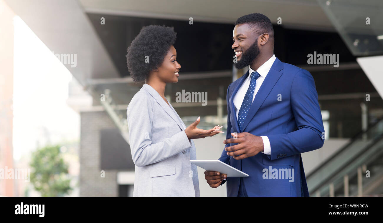 Two coworkers with digital tablet, discussing new project outdoors Stock Photo