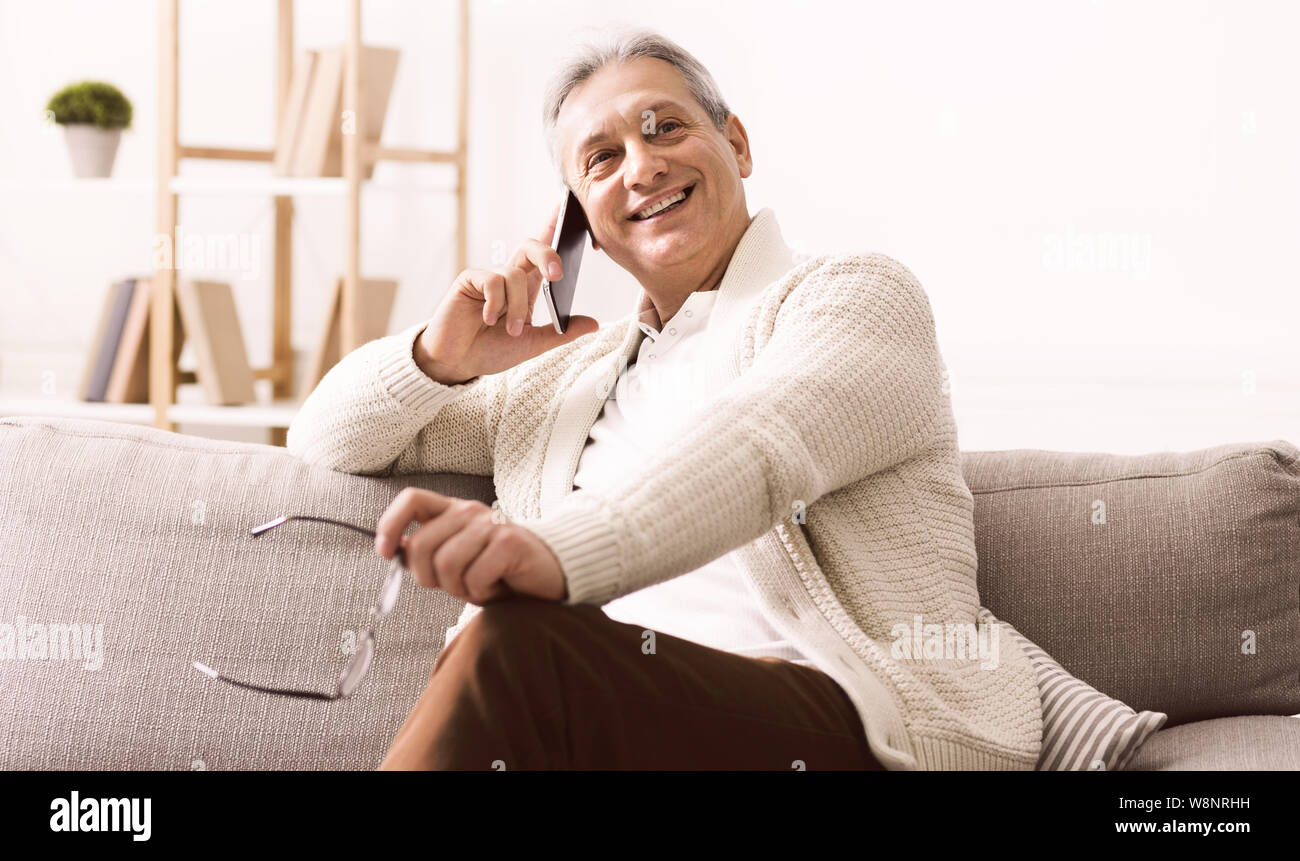 Happy retired man talking on phone, having rest Stock Photo