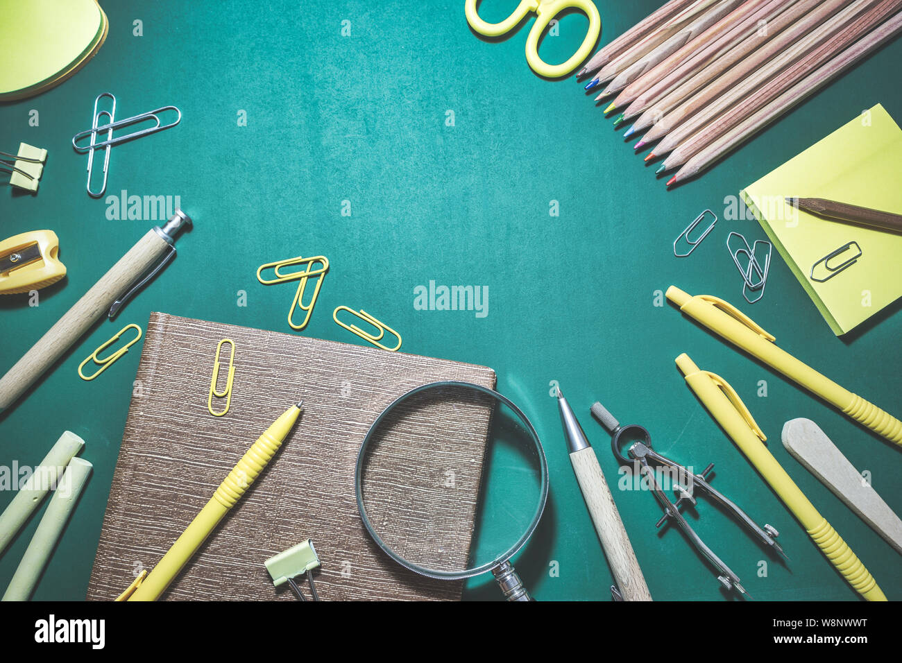 School supplies on chalkboard background, back to school concept. Top view with copy space. Stock Photo