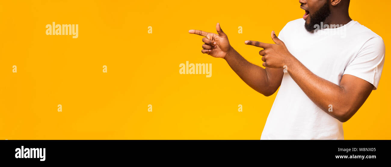Unrecognizable african guy pointing both hands aside at free space Stock Photo