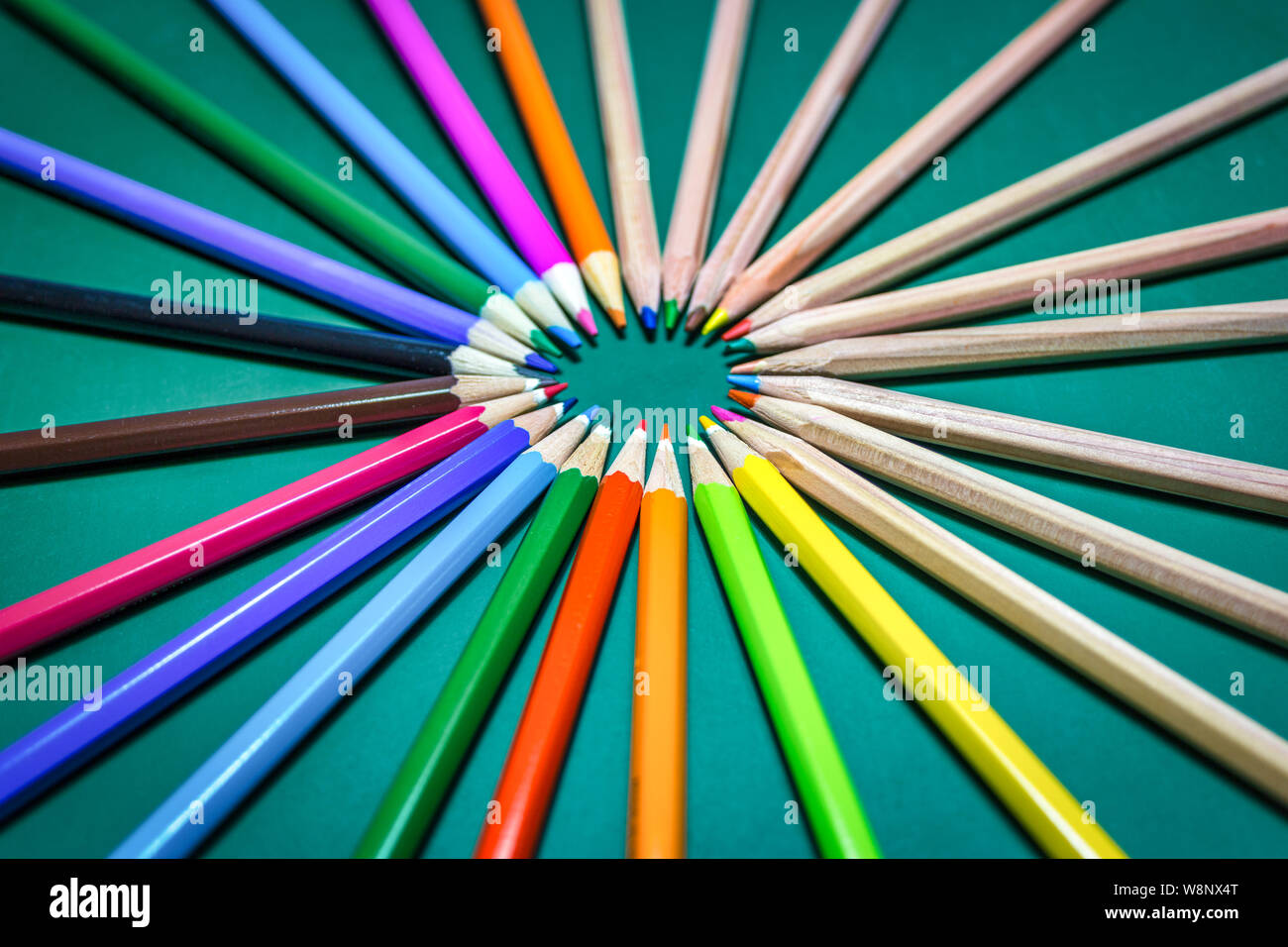 Many different colored pencils on chalkboard background. Back to school