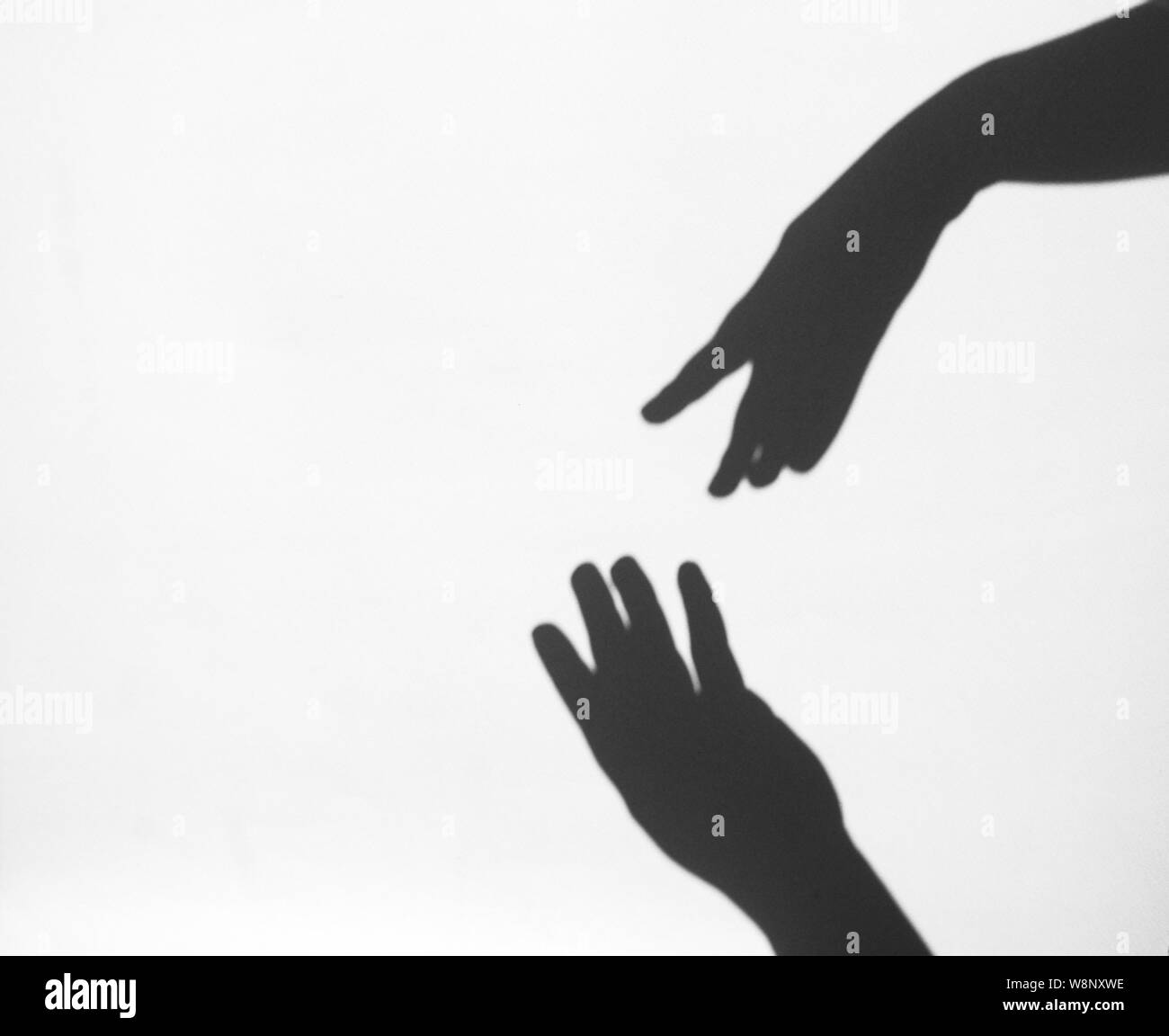 two women's hands reach for each other. Helping hand silhouette, female and male together. Stock Photo