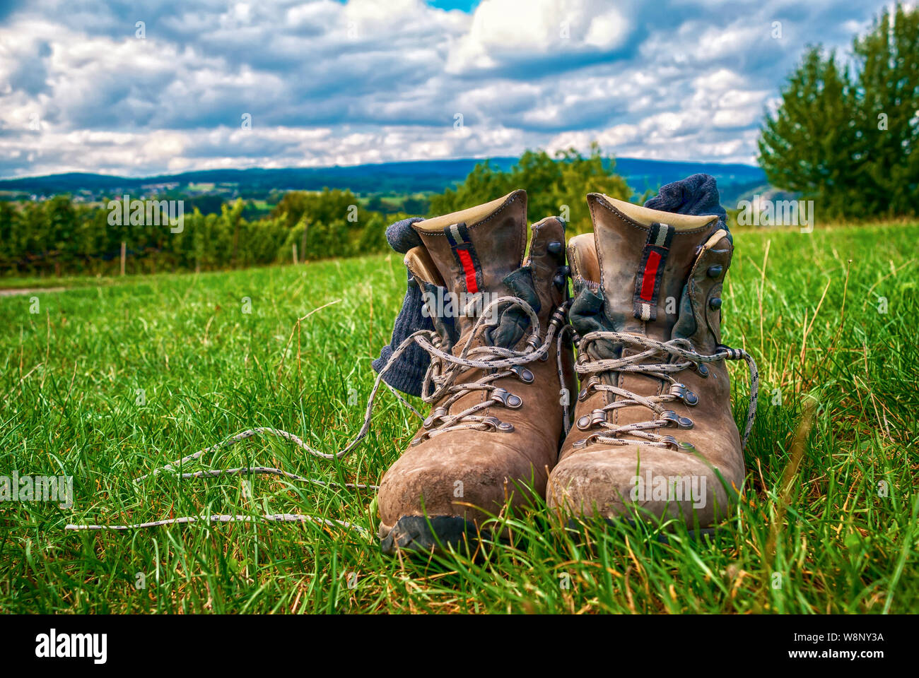 Worn Hiking boots in the meadows Stock Photo - Alamy