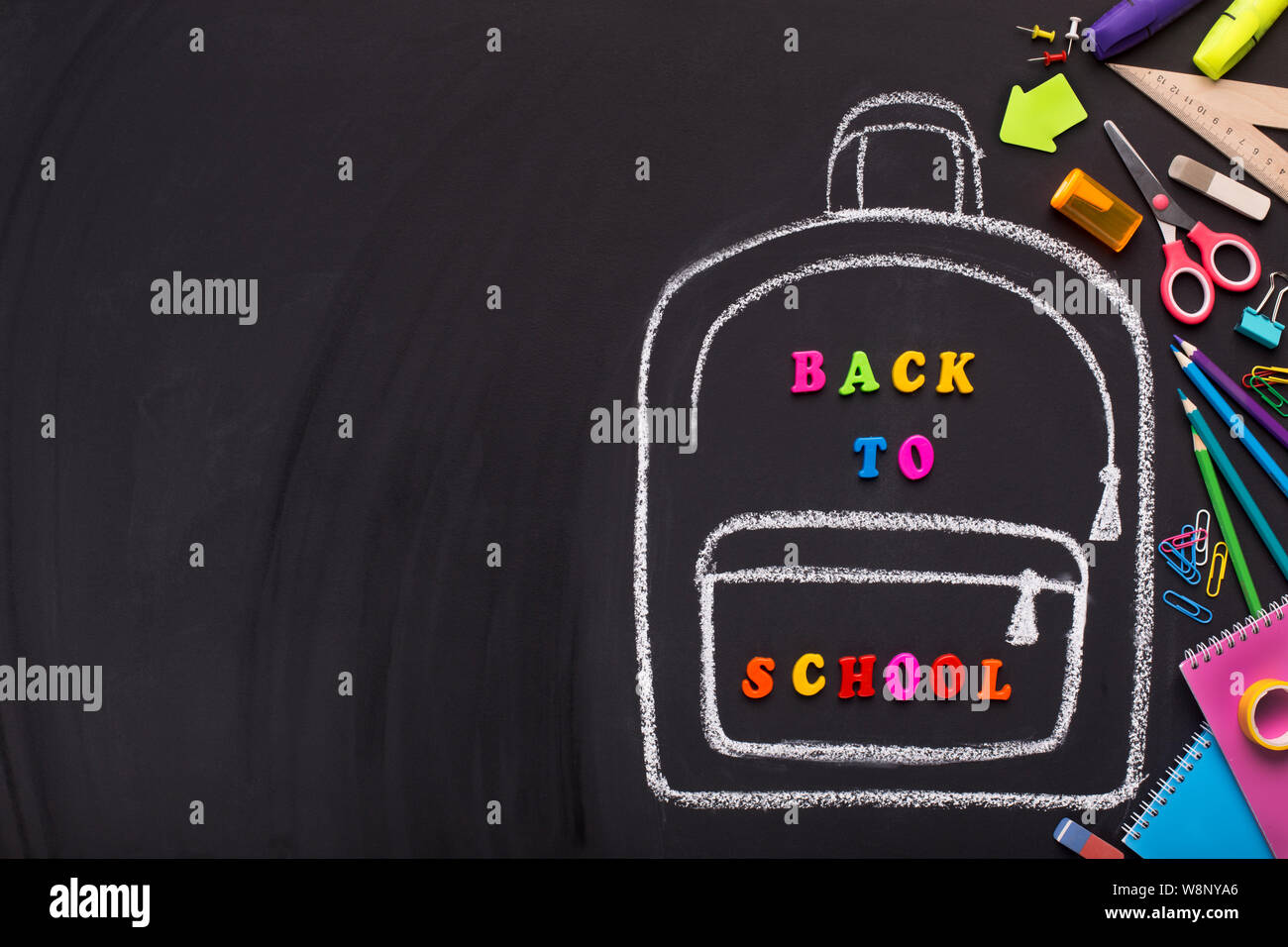 Chalk painted backpack with colored text on black background Stock Photo