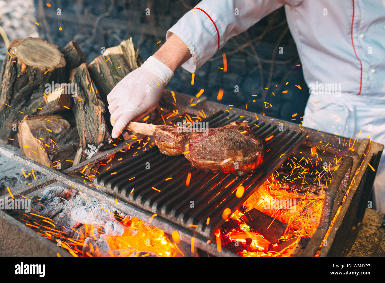 Chef Cooking steak. Cook turns the meat on the fire Stock Photo - Alamy