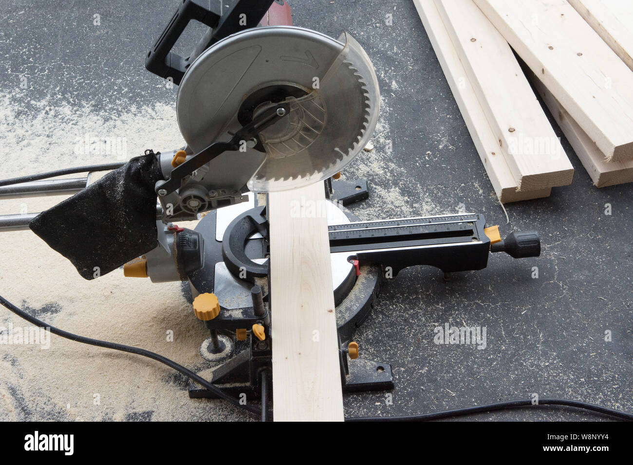 The Saw Stands On A Concrete Floor With A Block Of Wood Prepared