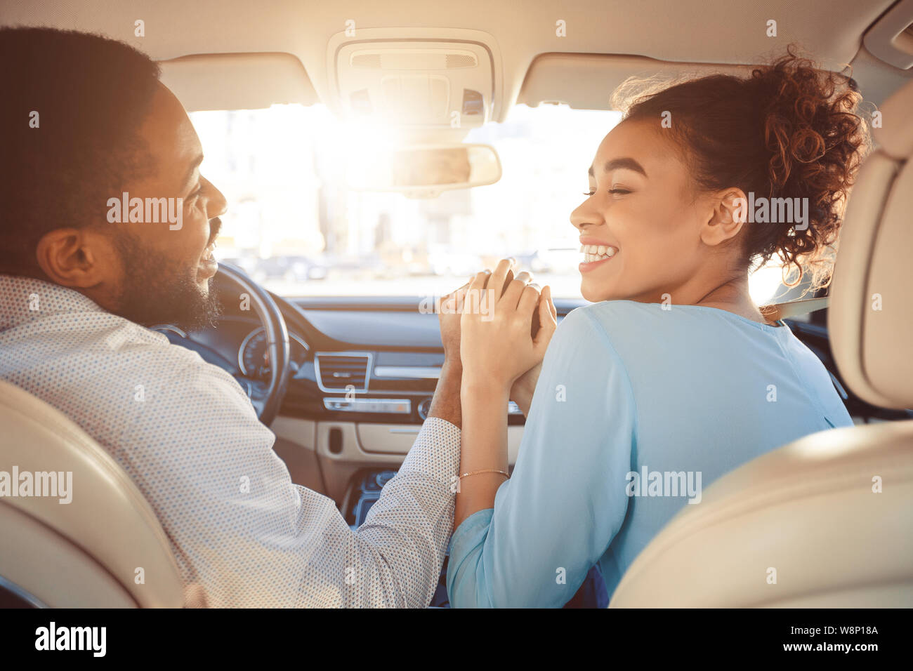 Happy couple holding hands, traveling in car Stock Photo