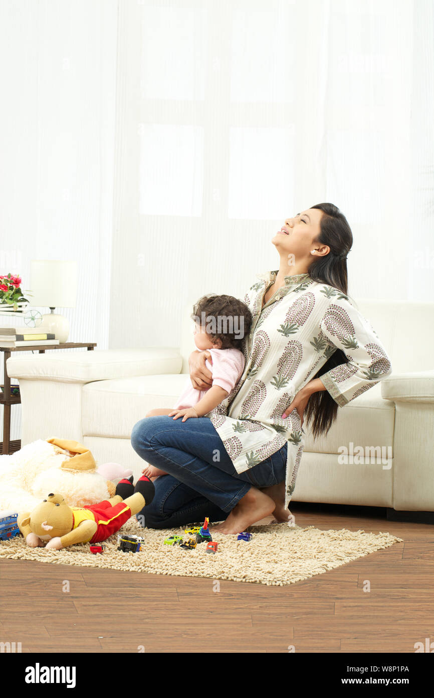 Mother carrying baby and suffering from lower back pain Stock Photo Alamy