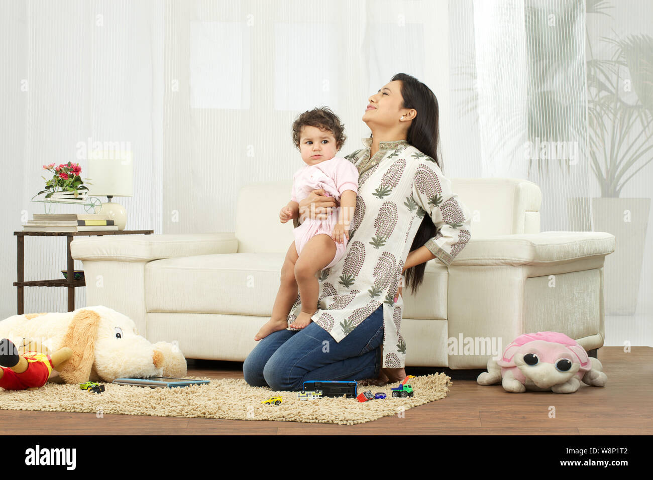 Mother carrying baby and suffering from lower back pain Stock Photo Alamy