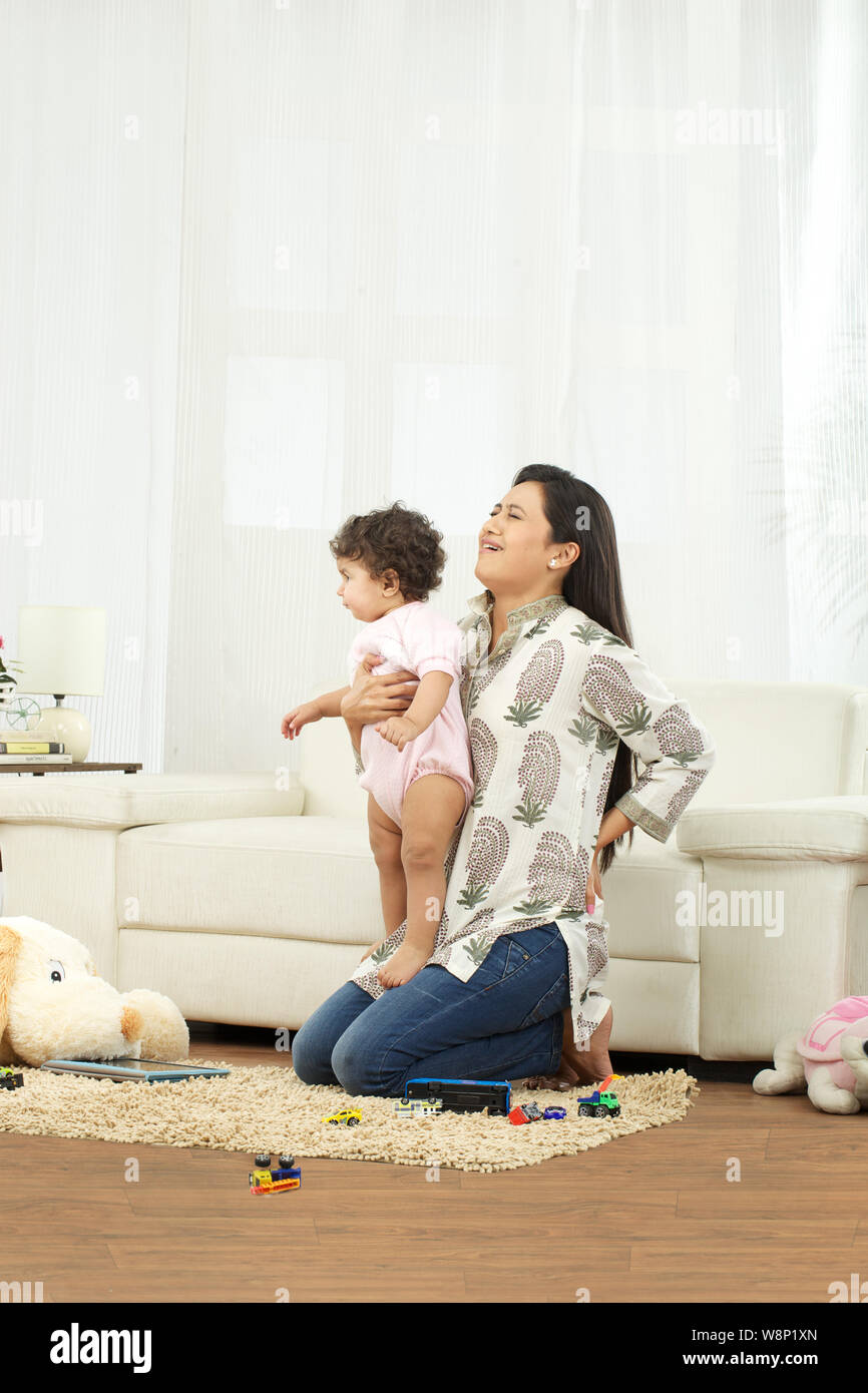 Mother carrying baby and suffering from lower back pain Stock Photo Alamy