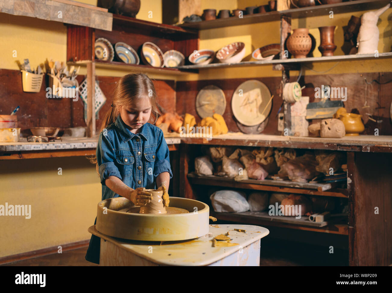 Pottery A little girl makes a vase of clay. Clay modeling