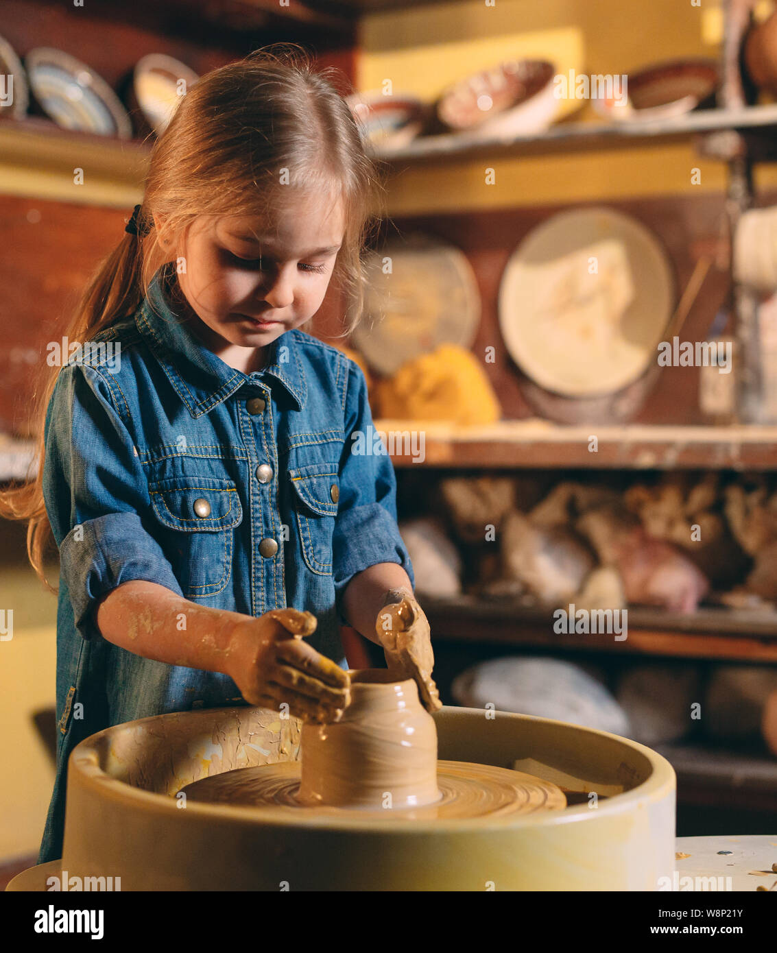 Pottery A little girl makes a vase of clay. Clay modeling