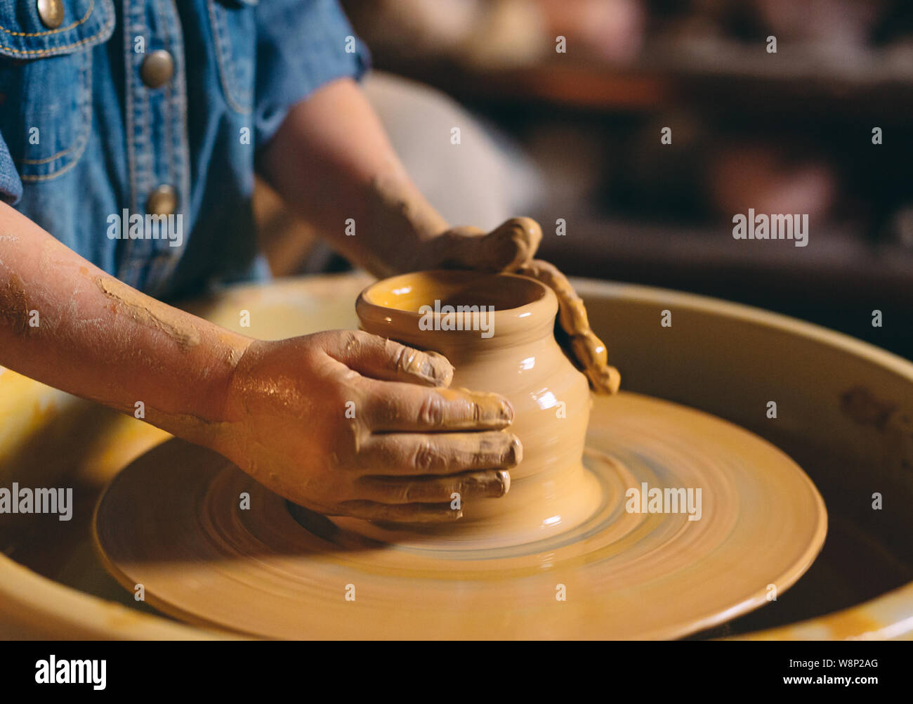 Pottery A little girl makes a vase of clay. Clay modeling