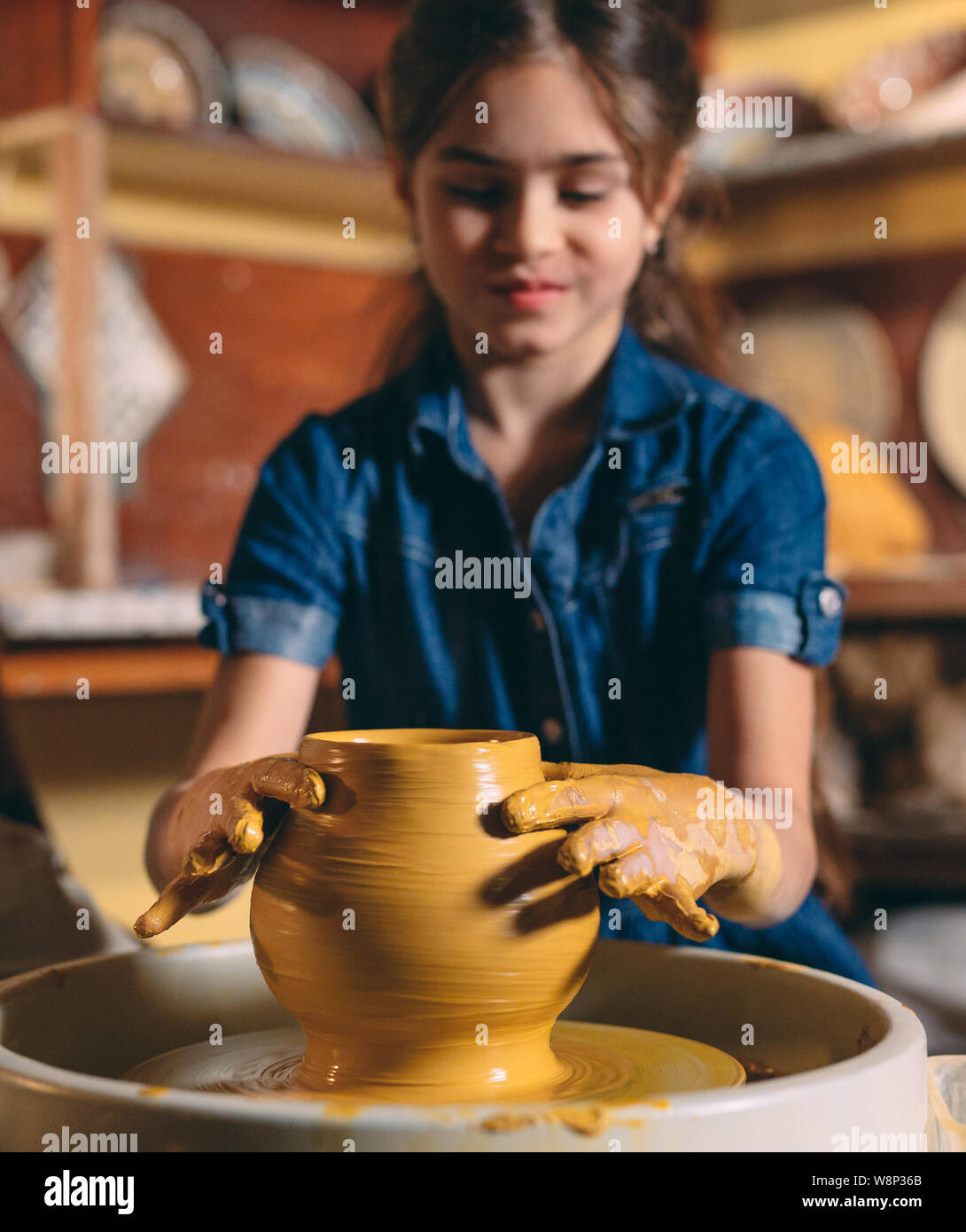 Pottery A little girl makes a vase of clay. Clay modeling