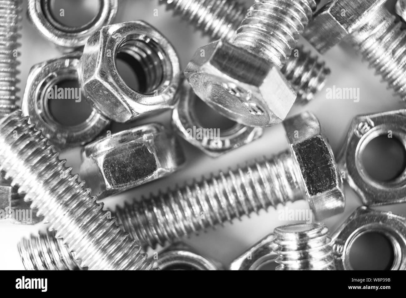 Metal bolts and nuts in a row background. Chromed screw bolts and nuts