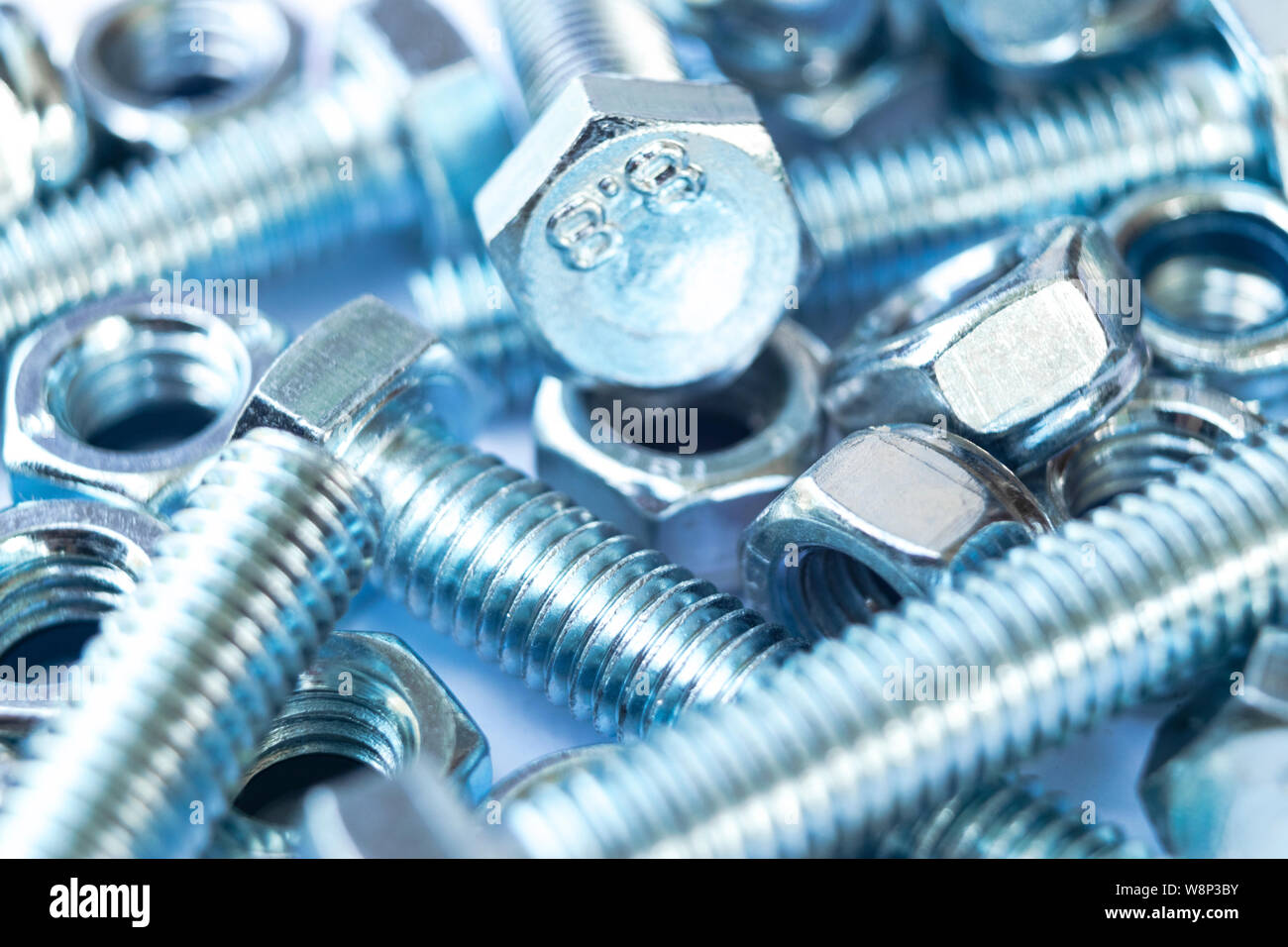 Metal bolts and nuts in a row background. Chromed screw bolts and nuts