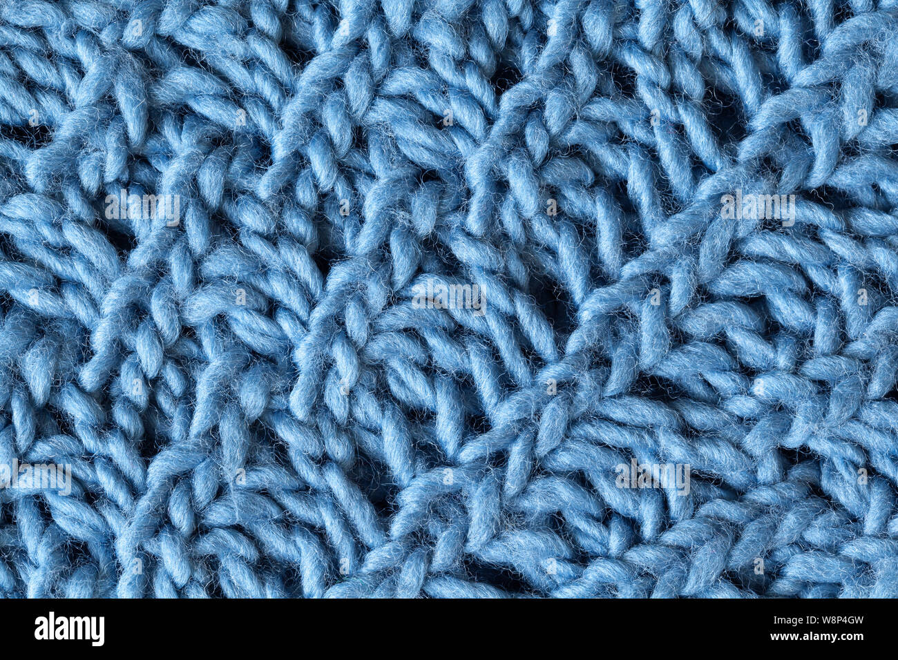 Knitted woolen textured surface, macro. Soft grey blue merino wool pattern backdrop, closeup. Autumn and winter flat lay. Scandinavian minimal style. Stock Photo
