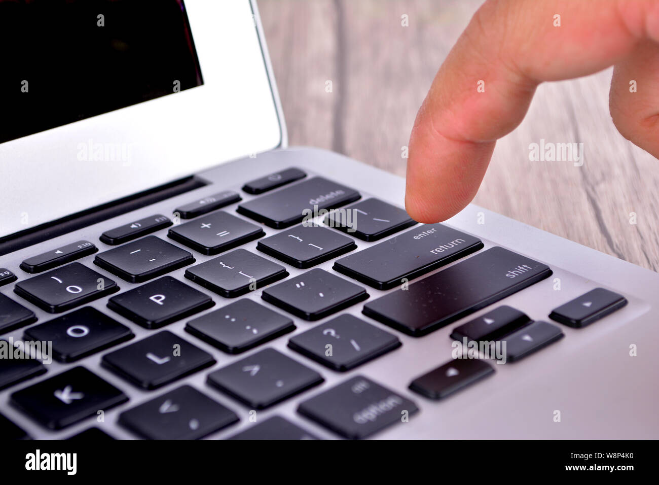 Hand touching laptop computer keyboard Focus on the keyboard Stock