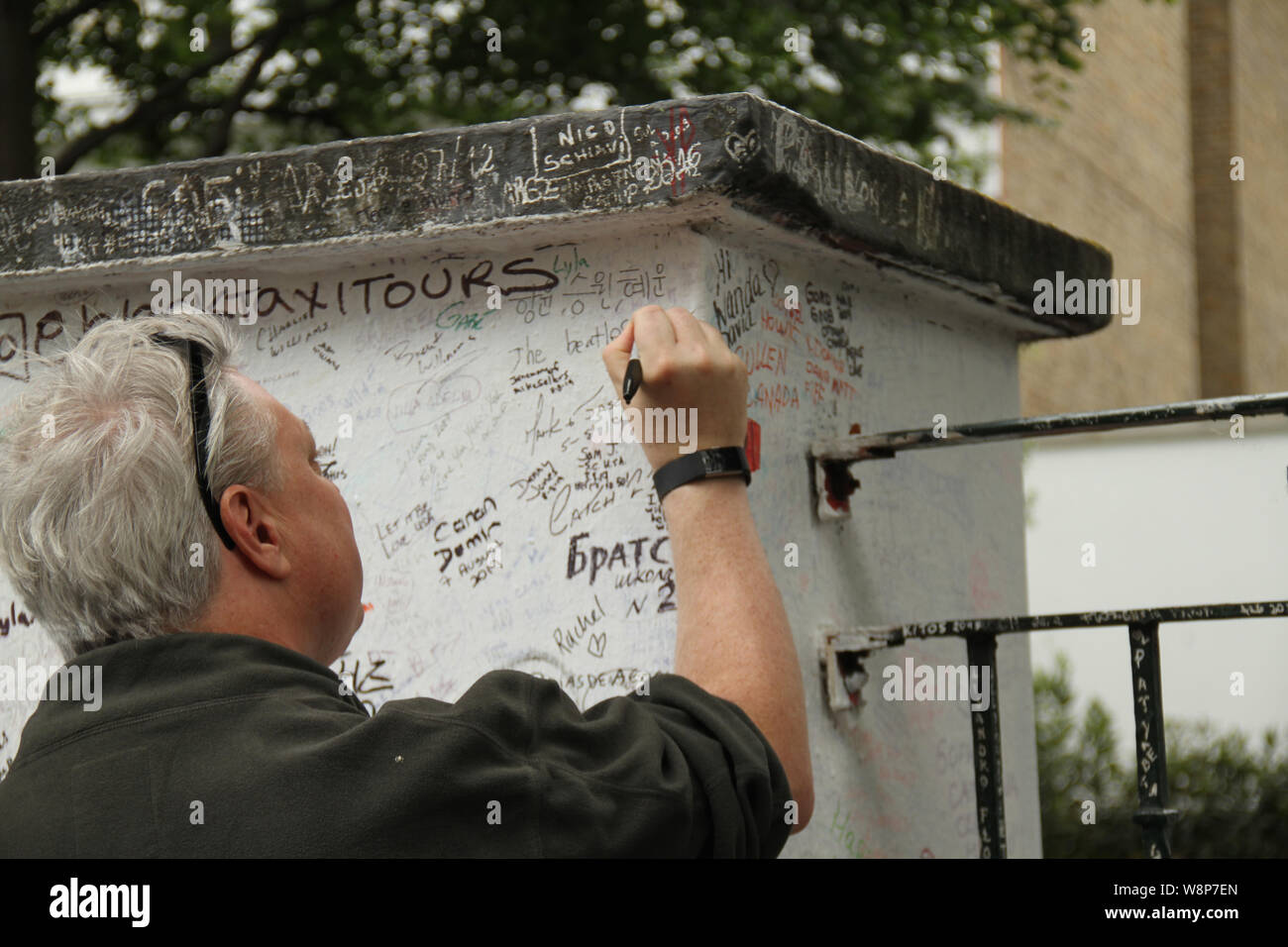 London, UK - 10 August 2019: A Beatles fan writes on the  Abbey Road Studio wall  on the weekend after the 50th anniversey of the Beatles penultimate album cover. On August 8, 1969 the four Beatles walked out of No. 3 Abbey Road after finishing recording for a 15 minute photos shoot by photographer Iain Macmillan. Credit: David Mbiyu Stock Photo