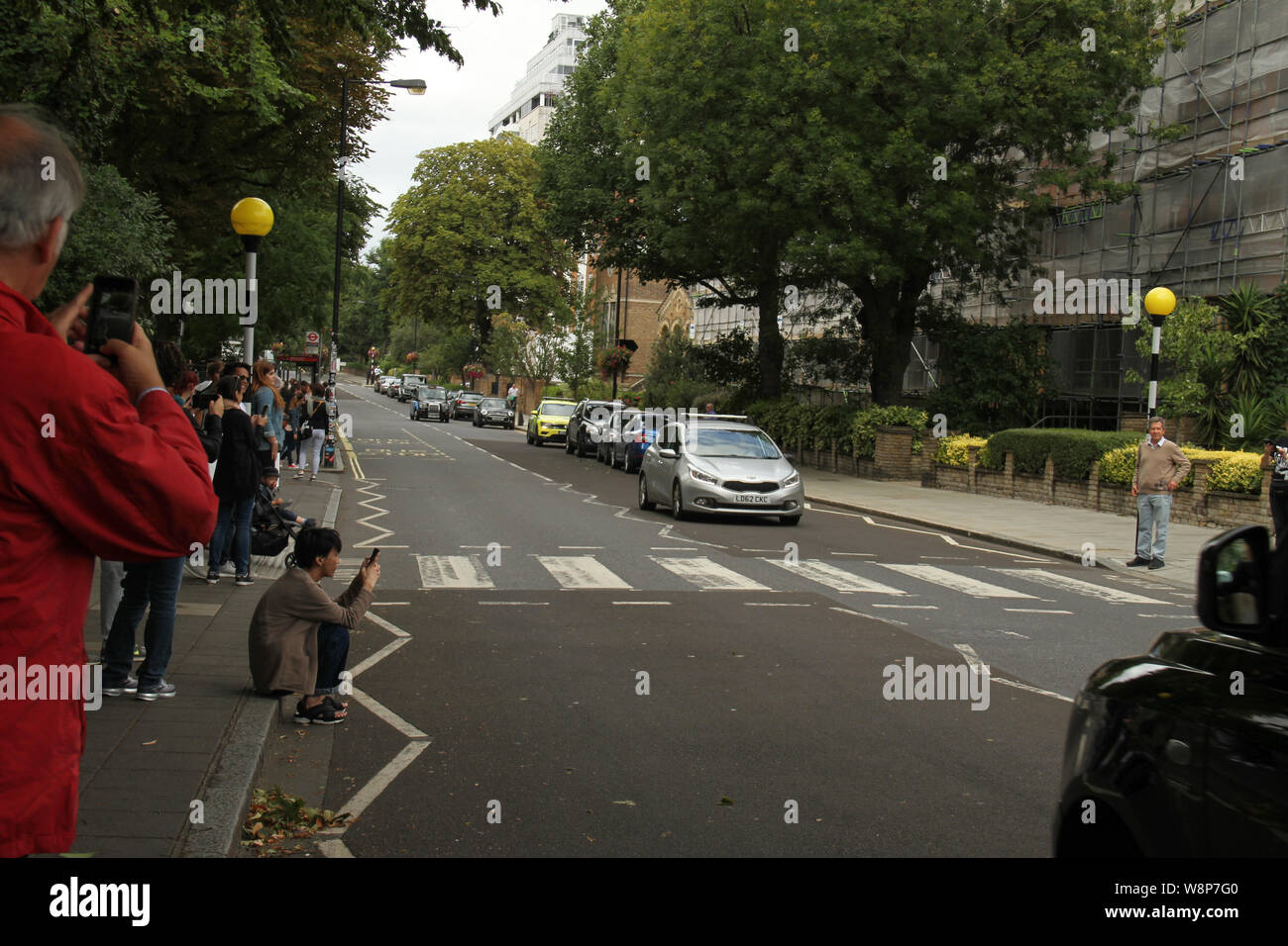 London, UK - 10 August 2019: Beatles fans seen by the Abbey Road NW8 zebra crossing on the weekend after the 50th anniversary of the Beatles penultimate album cover. On August 8, 1969 the four Beatles walked out of No. 3 Abbey Road after finishing recording for a 15-minute photos shoot by photographer Iain Macmillan. Credit: David Mbiyu/Alamy Live News Stock Photo