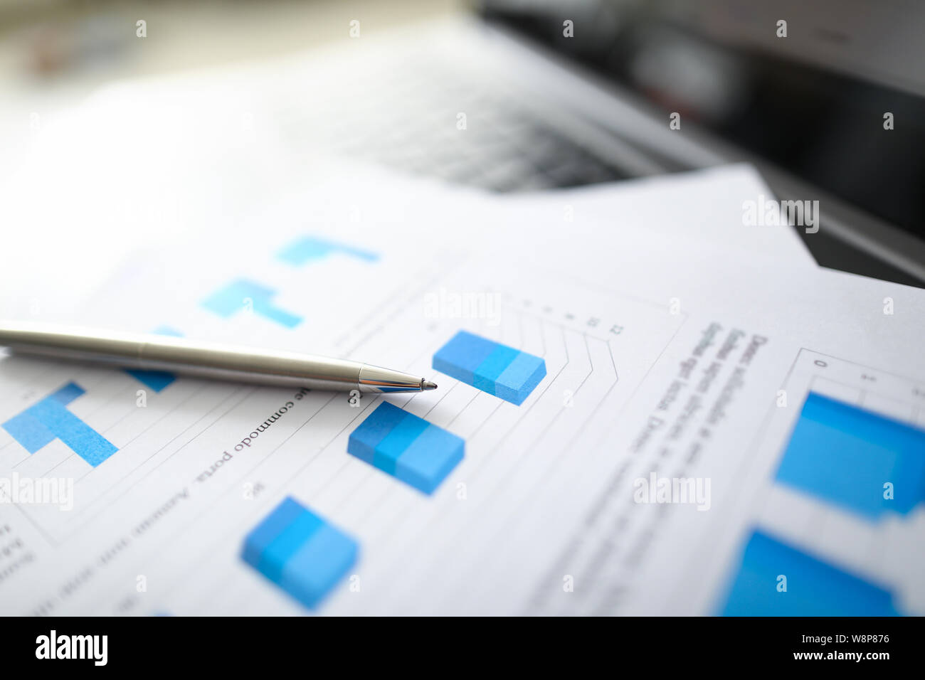 A silver pen lies on documents with Stock Photo