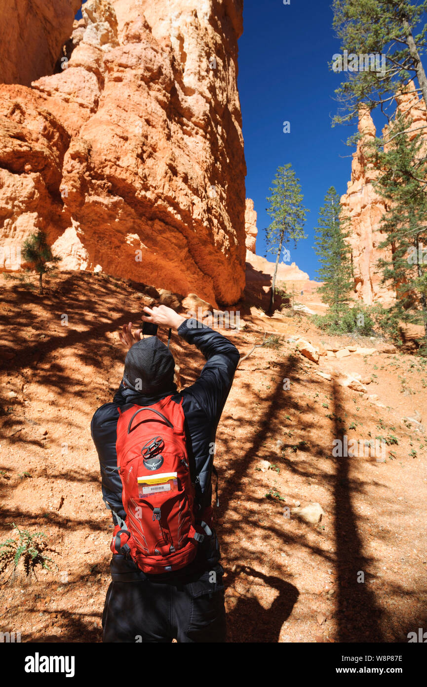 Hiker taking a picture of hoodoos at Bryce Canyon National Park, Utah, USA. Stock Photo