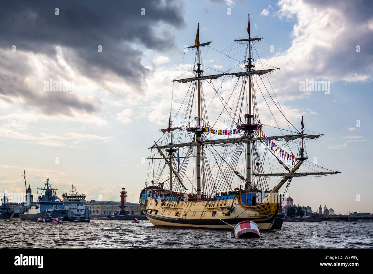 Three masted yellow wooden Tall Ship on the River Neva with Peter and Paul Cathedral in background in St Petersburg, Russia on 23 July 2019 Stock Photo