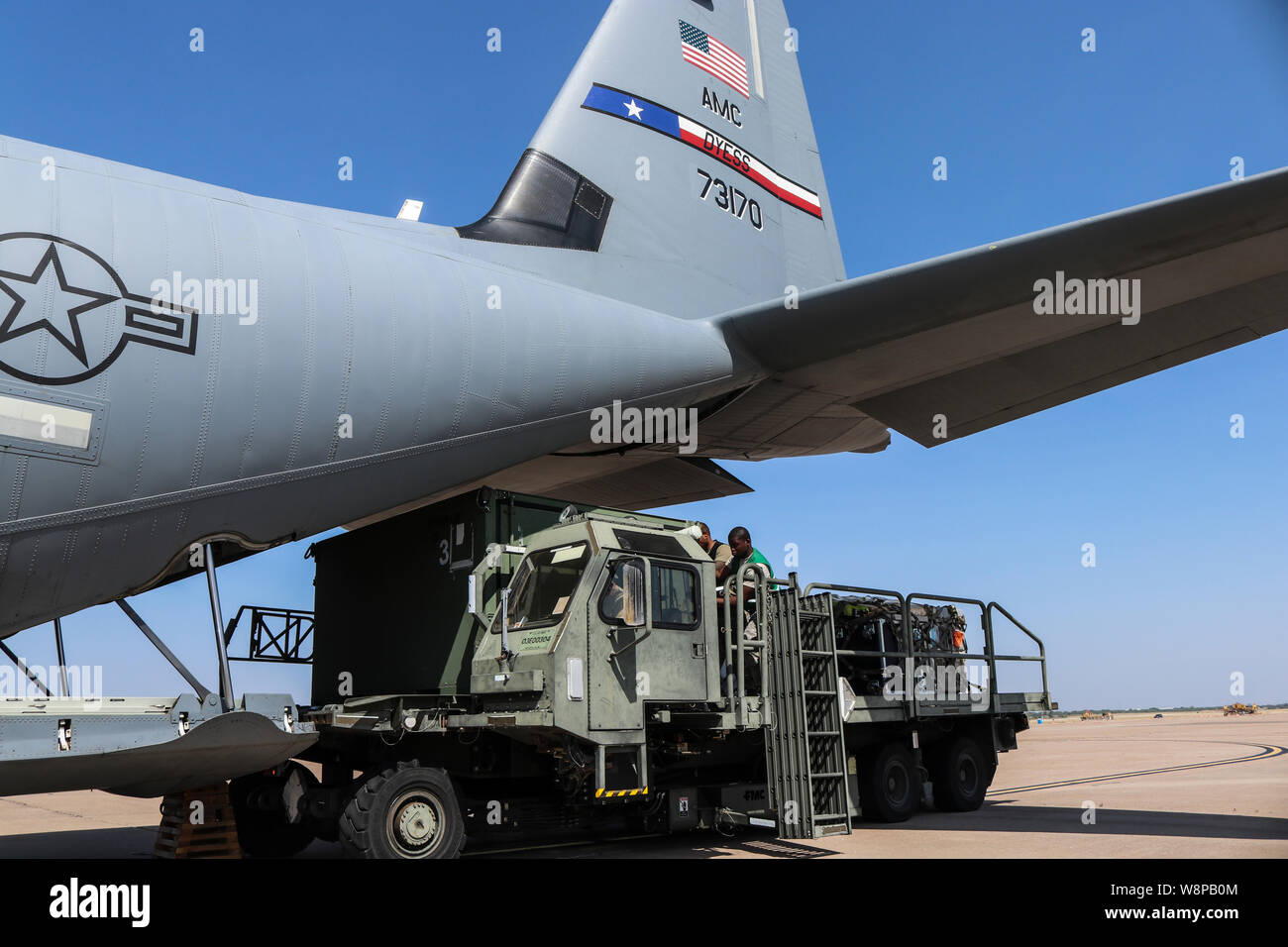 Airmen with the 7th Logistics Readiness Squadron load cargo onto a C