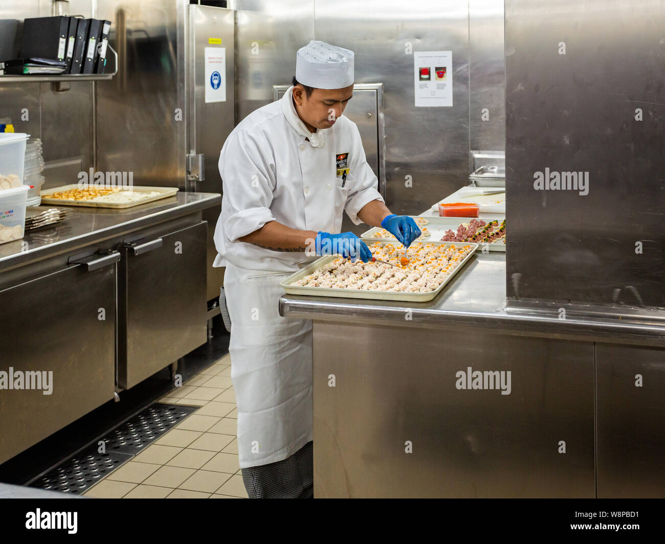 Behind the scenes view of food preparation in the kitchen, galley on board a large cruise ship at Sea in Queen Victoria in the Baltic Sea on 24 July 2 Stock Photo
