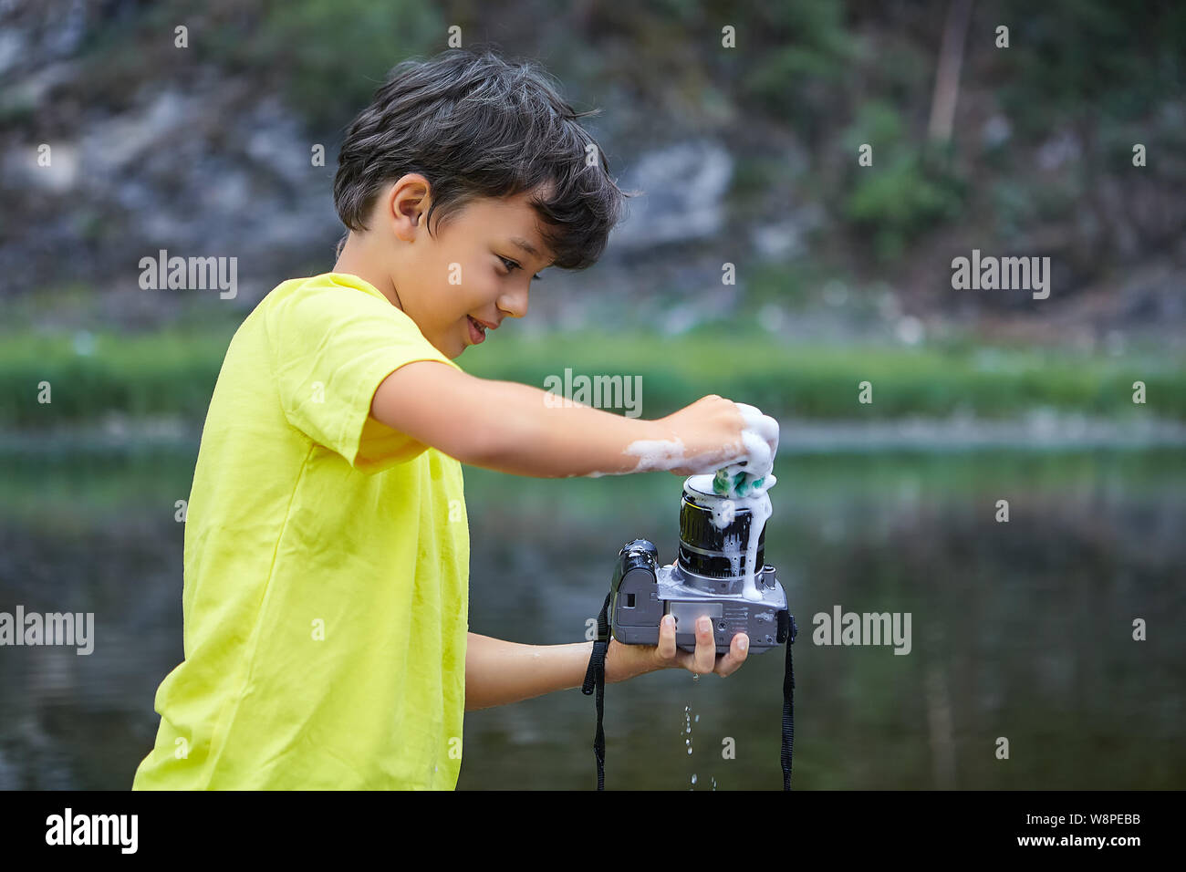 Smiling white bully boy is holding digital camera in his hands and washing  it by foam in the countryside Stock Photo - Alamy