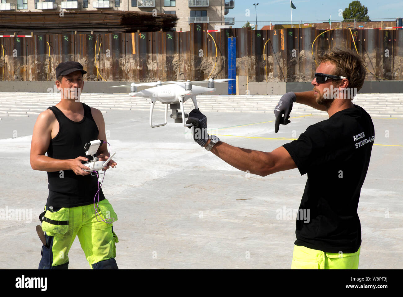 Archaeologist Jeppe Faerch-Jensen and colleague  Daniel Dalicsen, both from the Museum of South-East Denmark, prepare to fly a drone in order to photograph the large 500 years old ship wreck which just has been excavated at a building site near Koege, Denmark. (Photo by Ole Jensen/Alamy) Stock Photo