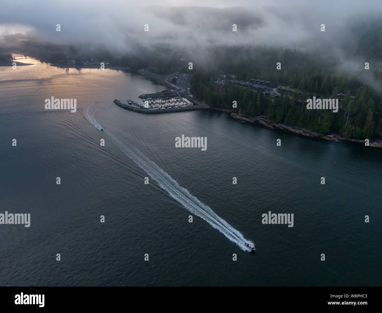 Aerial View of a small secluded town on the Pacific Ocean Coast during a cloudy summer sunrise