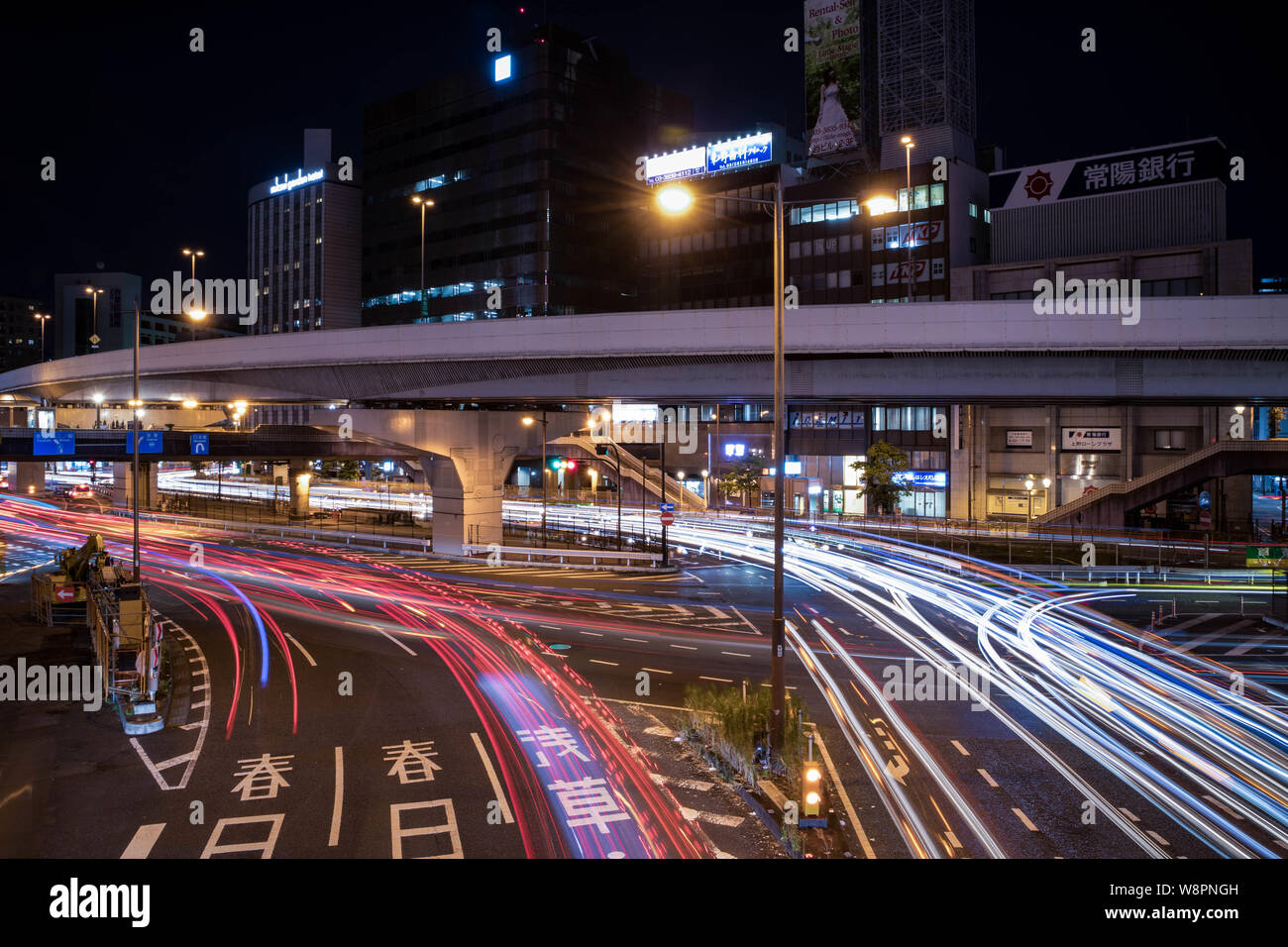 View of Ueno Station crossing at night. Motion blur light trail. Landscape orientation. Stock Photo