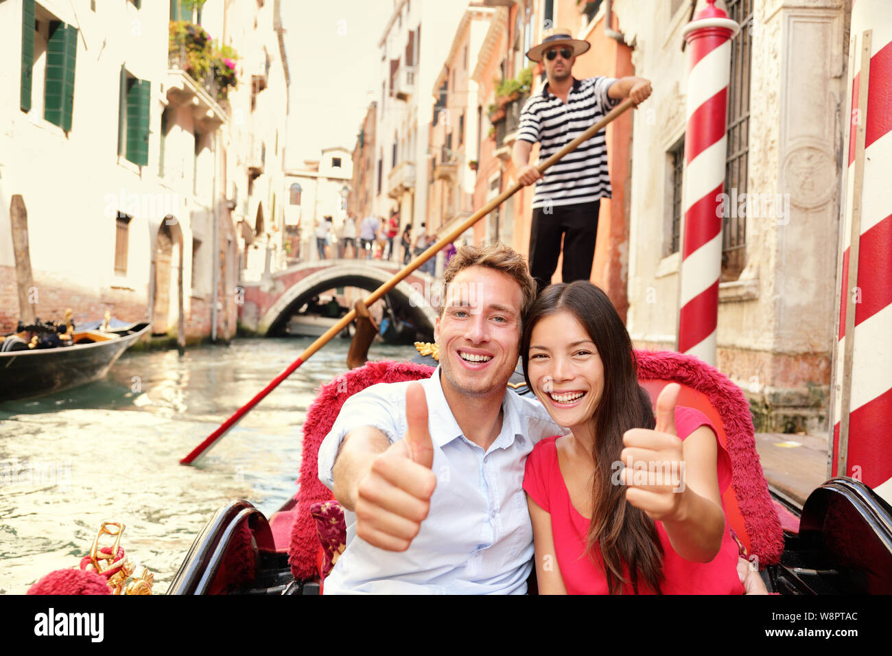 Tourists happy couple traveling in Venice gondola giving thumbs up hand