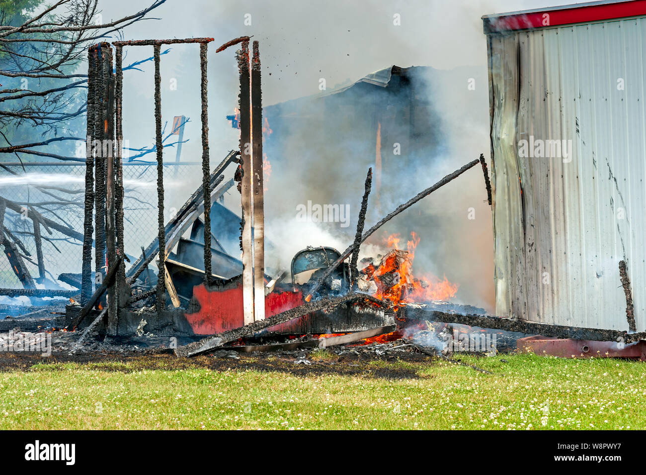 destroyed structure with small fire still burning Stock Photo