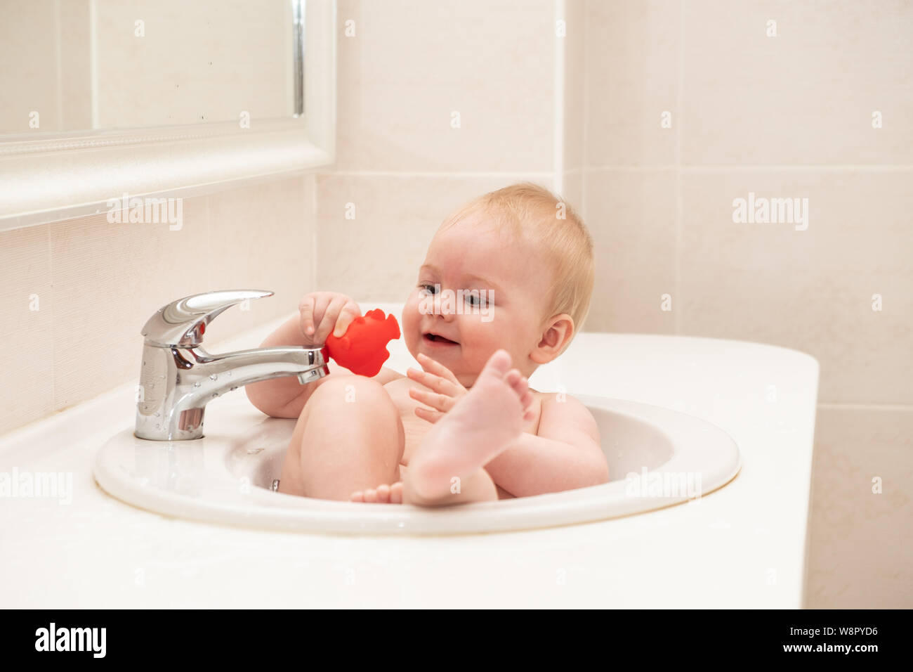 A happy little girl is bathing in the hotel sink Stock Photo Alamy