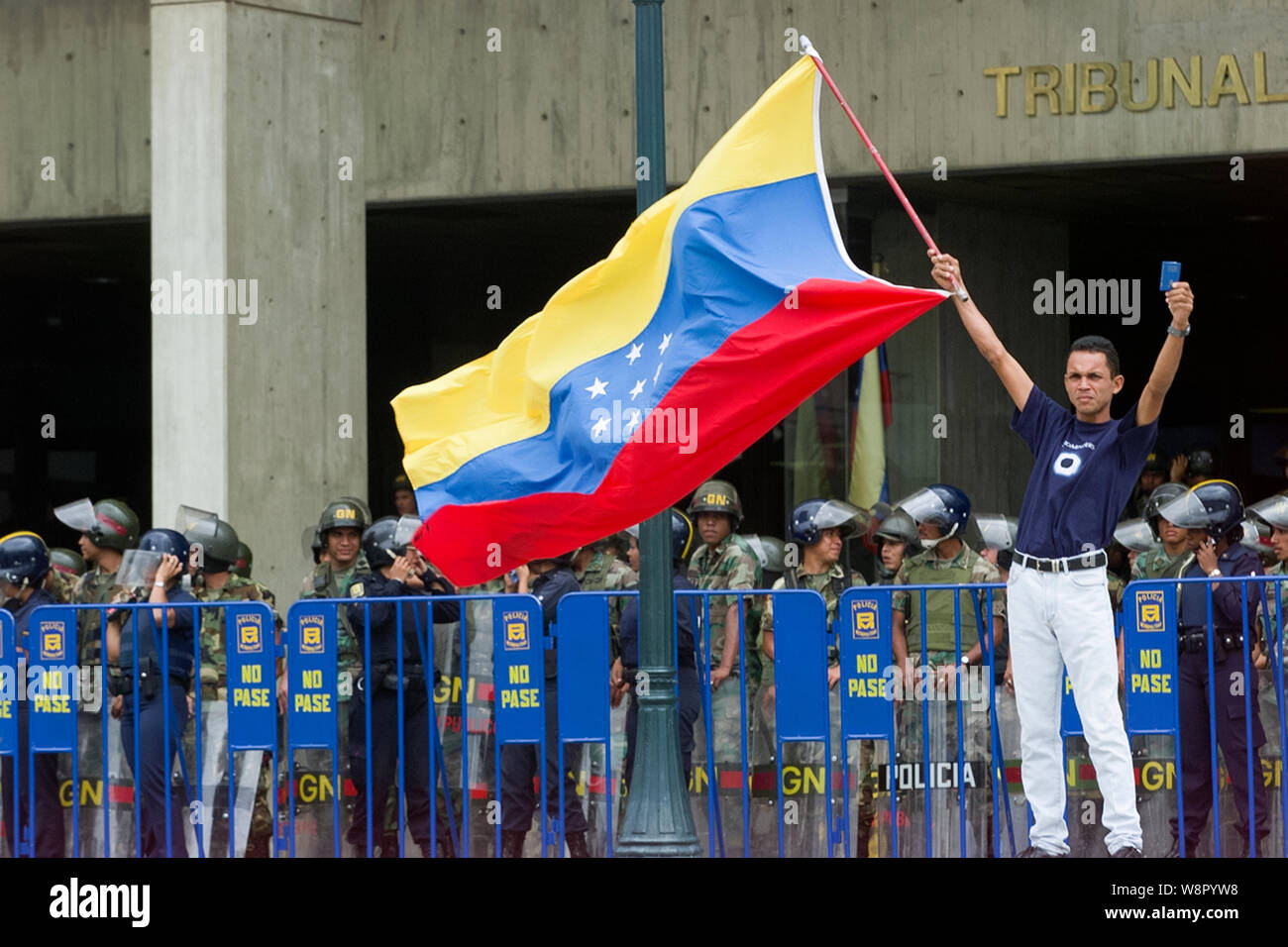A Venezuelan holds a Venezuelan flag and a Venezuelan Constitution during a protest against Venezuelan President Hugo Chavez Stock Photo