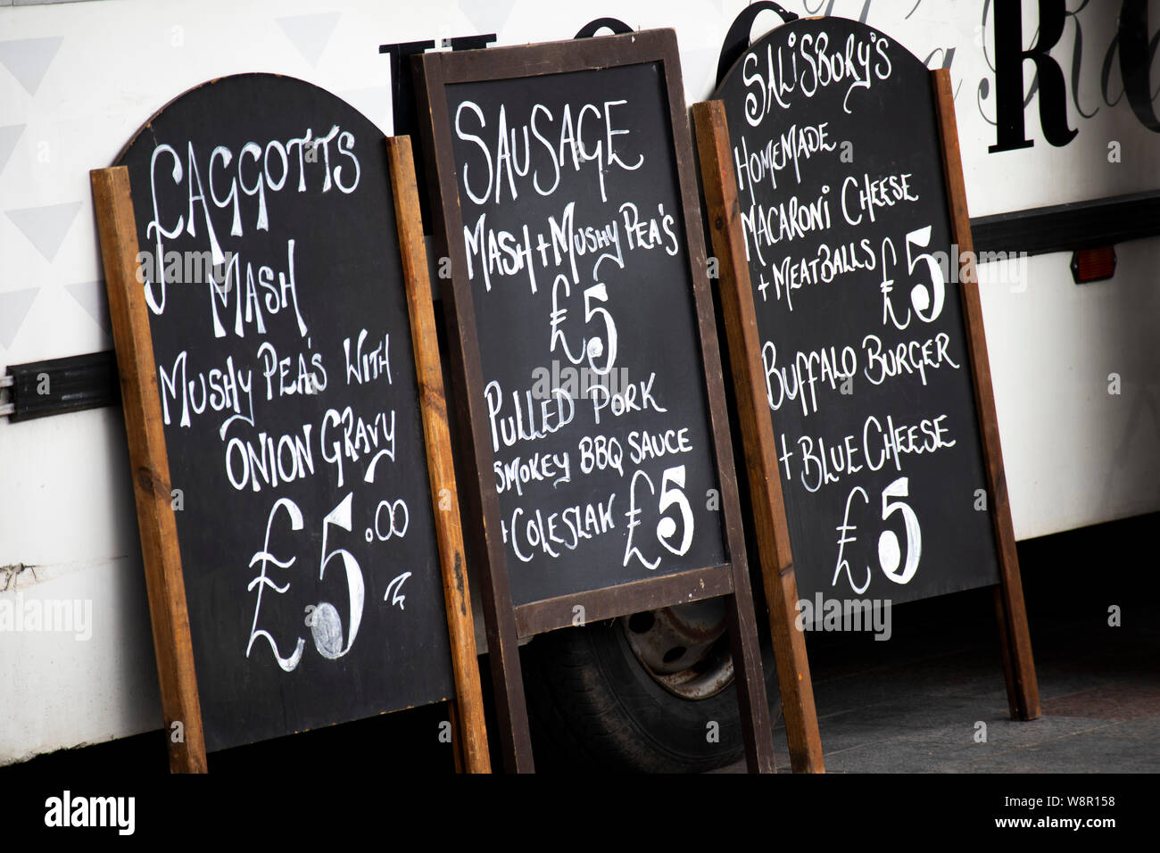 Menu and price boards propped up against mobile food trailer at weekly Saturday marketplace Stock Photo