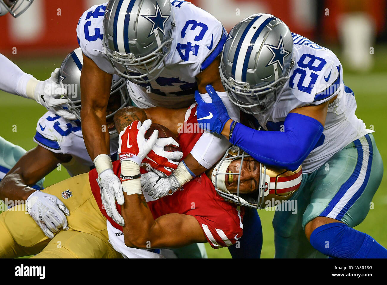 San Jose, California, USA. August 10, 2019: San Francisco 49ers wide  receiver Shawn Poindexter (1) finds himself alone in Cowboy territory being  tackled by Dallas Cowboys linebacker Nate Hall (43) and Dallas