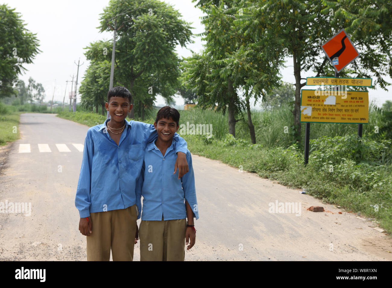 Two schoolboys standing with arm around and smiling, India Stock Photo ...