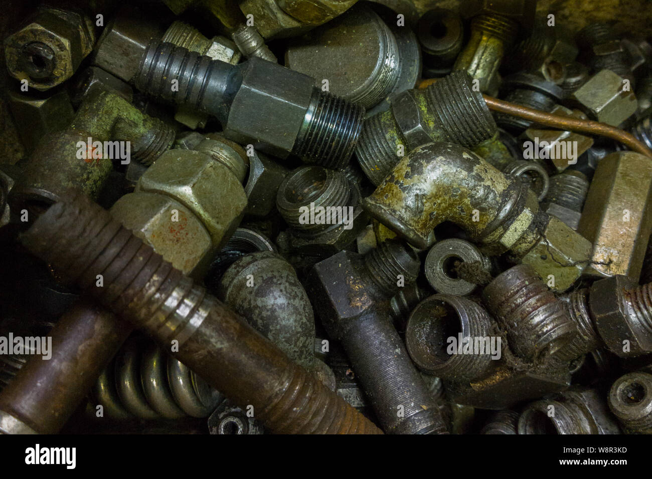 a pile of old dirty hydraulic fittings and tube parts closeup with selective focus Stock Photo