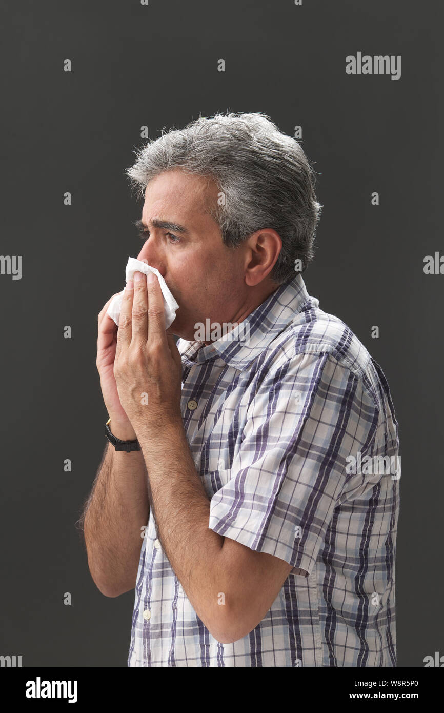 Senior man blowing nose with handkerchief Stock Photo Alamy