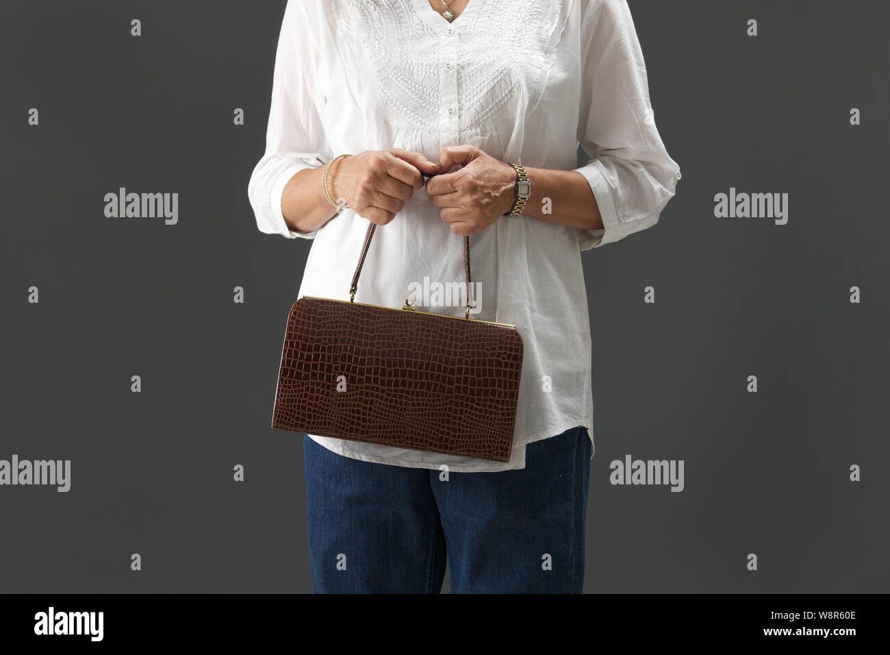 Midsection view of a old woman holding handbag Stock Photo