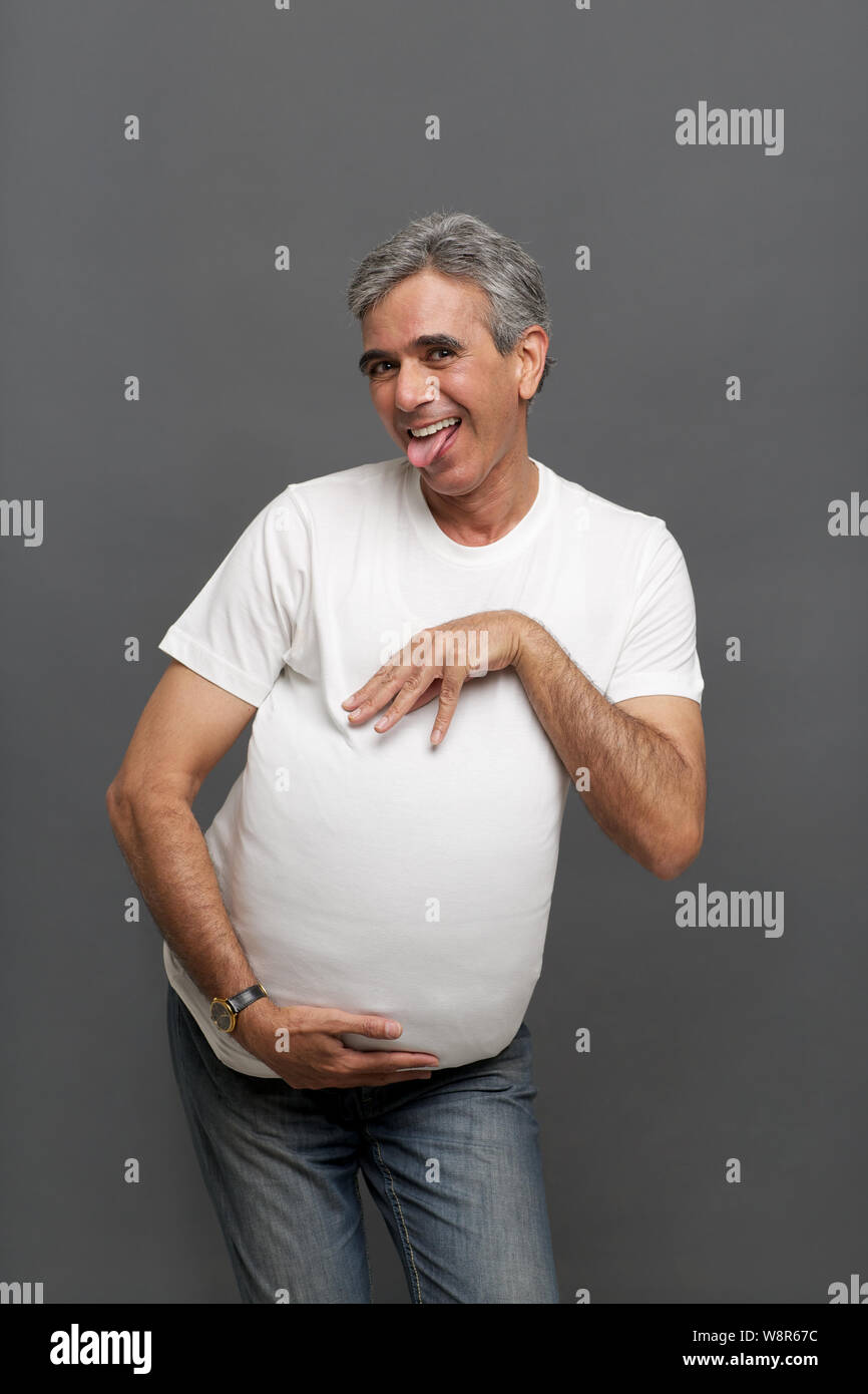 Senior man pretending to be a pregnant woman Stock Photo