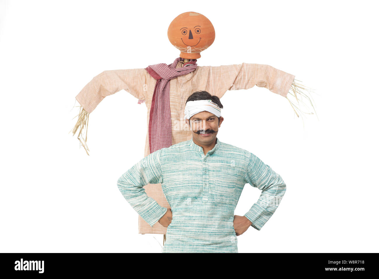 Farmer standing with his arms akimbo in front of a scarecrow Stock ...