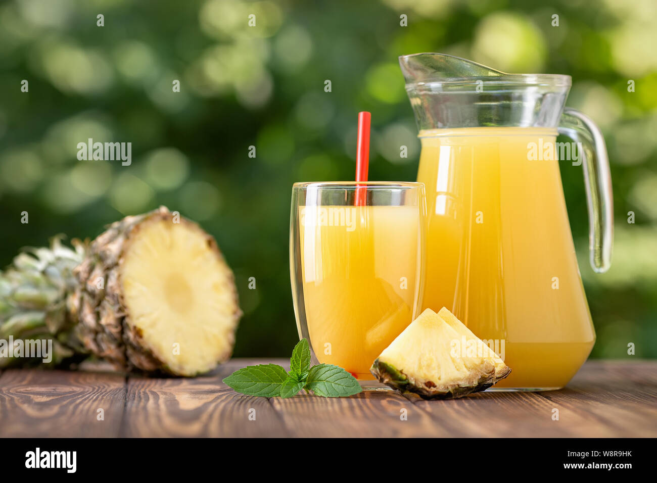 https://c8.alamy.com/comp/W8R9HK/fresh-pineapple-juice-in-double-sided-wall-glass-and-jug-with-ripe-fruit-on-wooden-table-outdoors-summer-refreshing-drink-W8R9HK.jpg